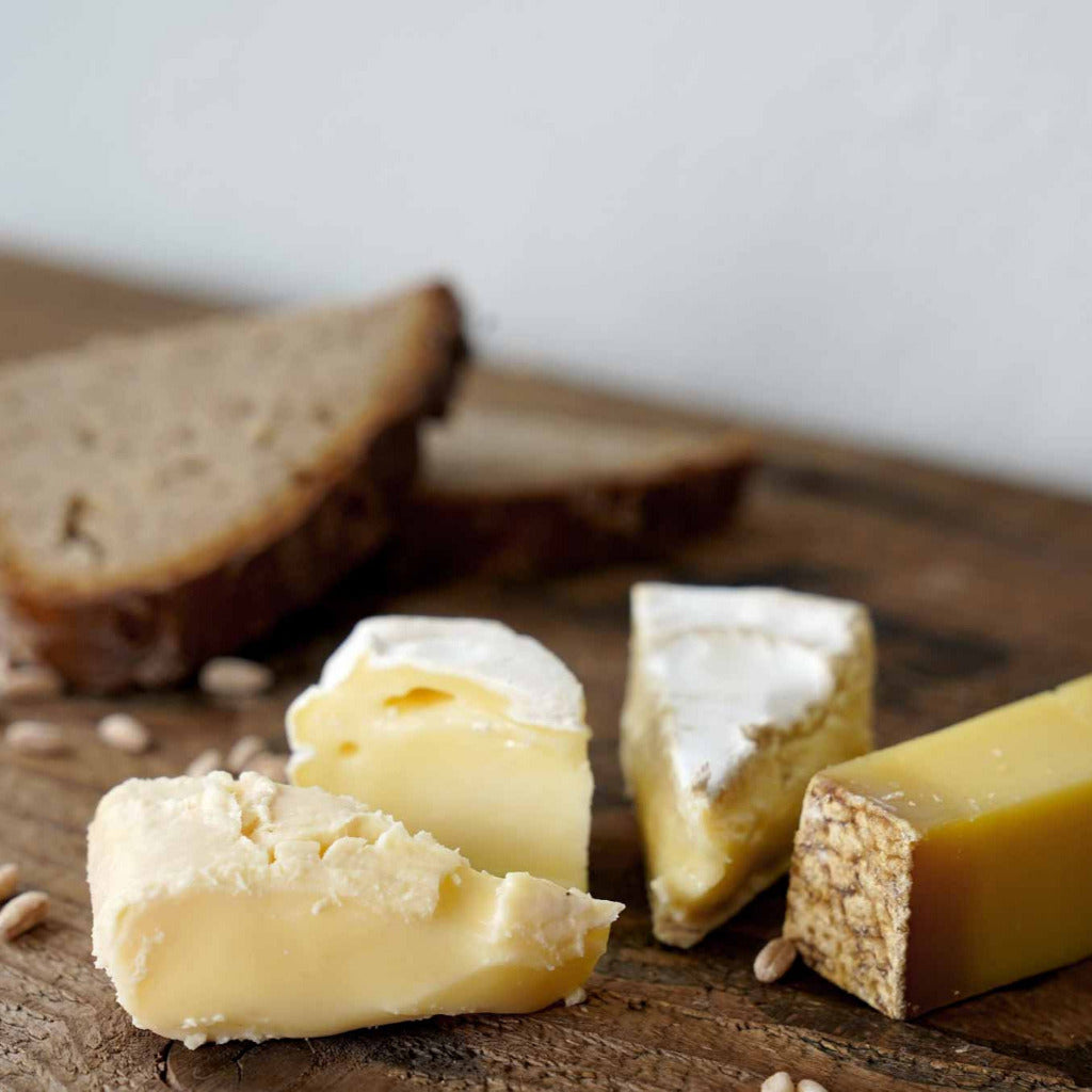 Kaese und Brot auf einem Holzbrett