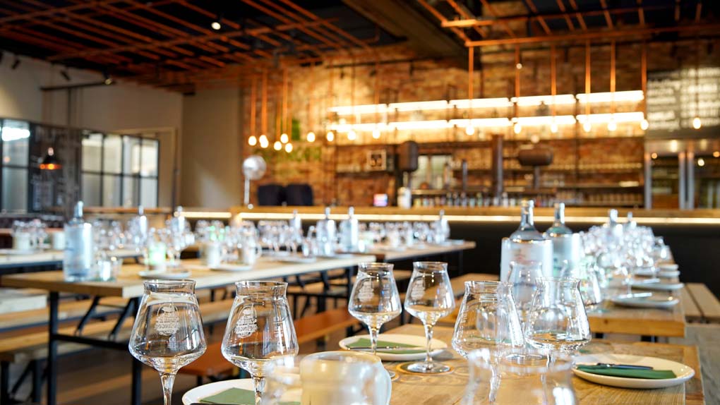 ein gedeckter Tisch mit Weingläsern mit einer Bar im Hintergrund