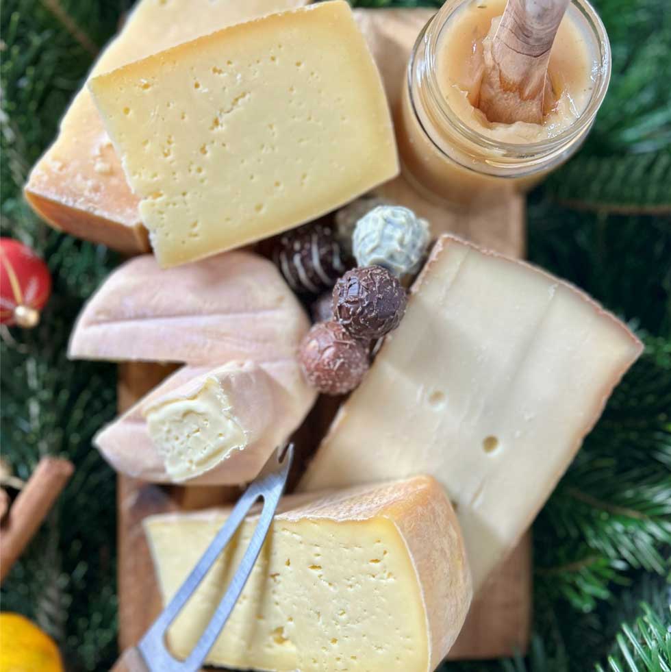 Das Bild zeigt eine Käseplatte mit 5 Käsen und Schoko-Käse Pralinen