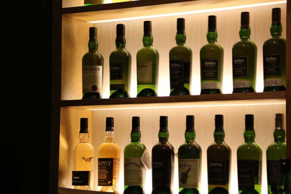 Whiskey in Flaschen in einem beleuchteten Regal